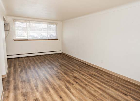 A room with wooden flooring and a window.