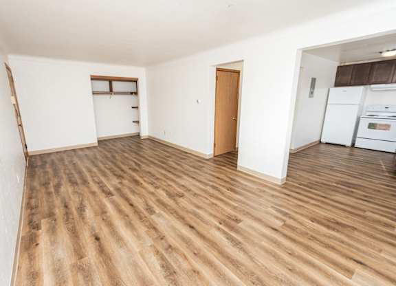 A room with wooden flooring and white walls.