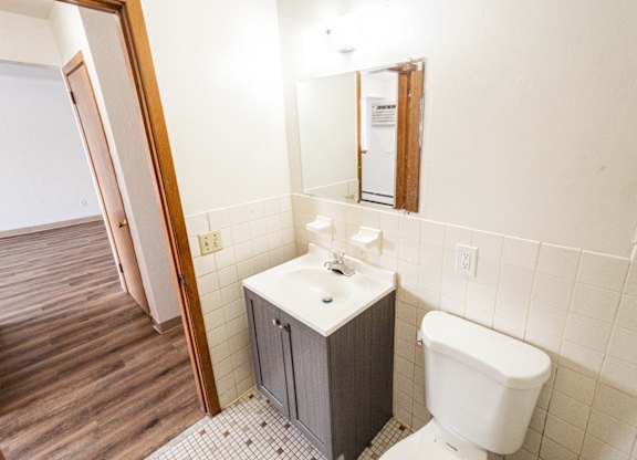 A white toilet sits next to a sink in a small bathroom.
