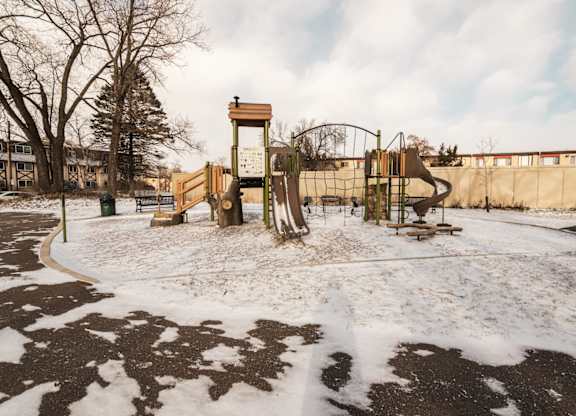 A playground with a wooden swing set and a climbing frame.
