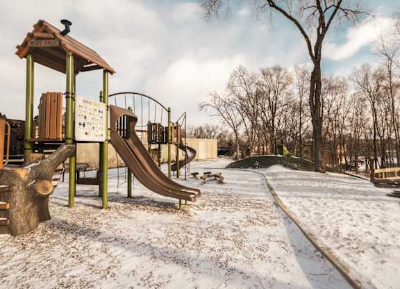 A playground with a slide and a wooden structure.