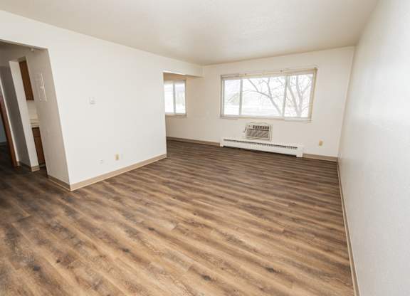 A room with wooden flooring and a window.