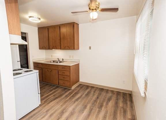 A kitchen with wooden floors and white appliances.