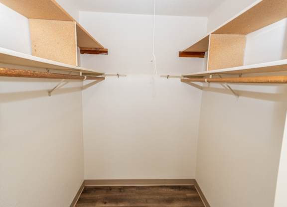 Empty white walk in closet with shelves.