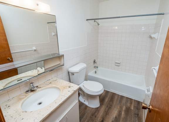 A bathroom with a sink, toilet, and bathtub.