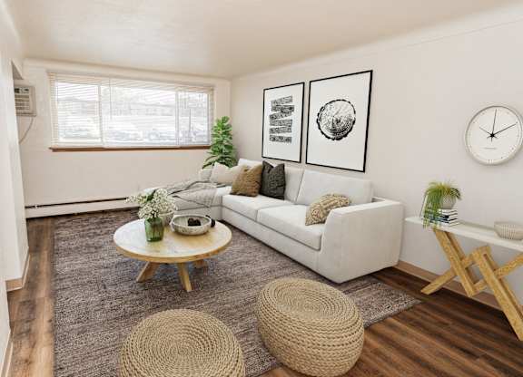 A living room with a white couch, a wooden coffee table, and a woven ottoman.
