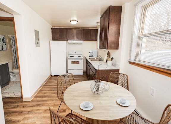 A kitchen with a table and chairs in the middle of the room.