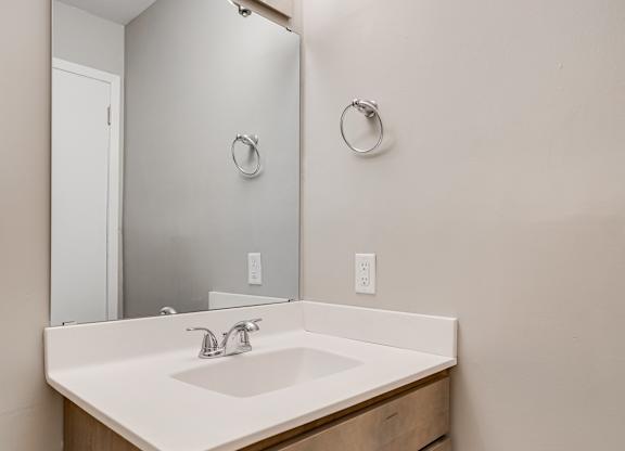 A bathroom with a sink and a mirror above it.