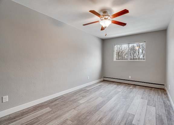 A room with a ceiling fan and a window.
