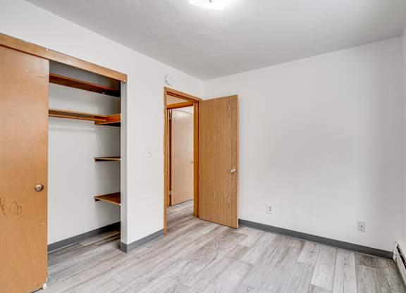 A room with a white wall and a brown door.