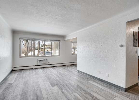 A room with a window and a wooden floor.