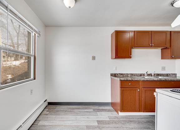 A kitchen with white appliances and wooden cabinets.