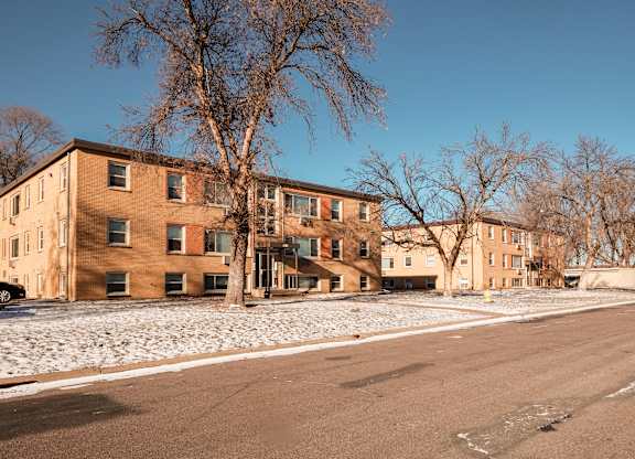 Apartment building with a tree in front of it.
