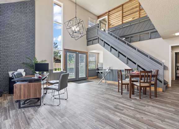 A modern living room with a staircase and a dining table.
