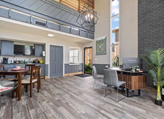 A modern open plan living and working space with a kitchen, dining table and a home office.