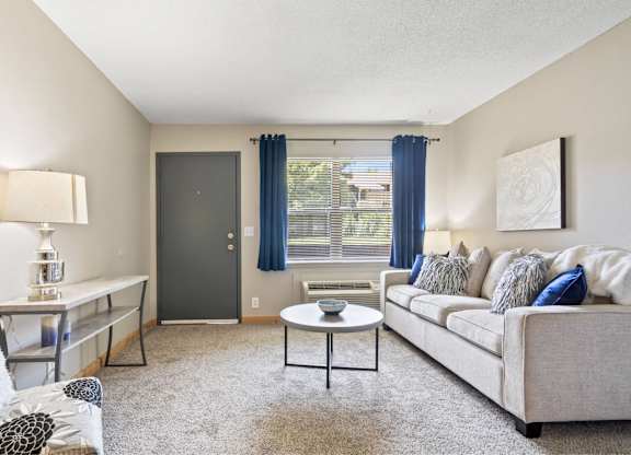 A living room with a couch, a table, and a chair.