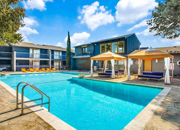A swimming pool surrounded by a stone border and a metal ladder.
