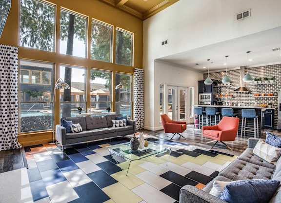 A living room with a grey sofa and a black and white checkered floor.