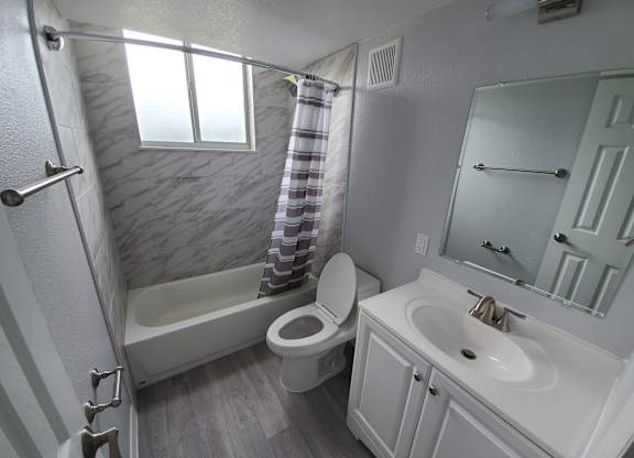A bathroom with a toilet, sink, and bathtub.