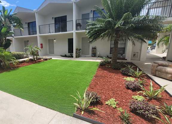 A white building with a green lawn in front.