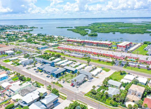 A bird's eye view of a city with buildings, roads, and a body of water.