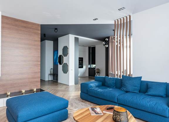 A blue couch is in the middle of a modern living room.