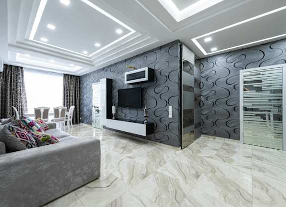 A modern living room with a grey sofa and a television.