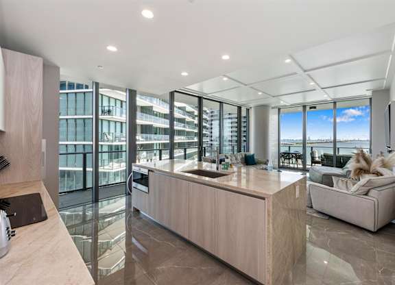 A modern kitchen with a large island and a view of the city.