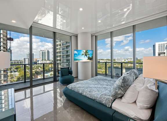 A bedroom with a large bed and a view of the city.