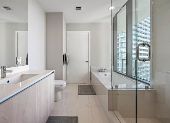A modern bathroom with a glass shower stall and a toilet.