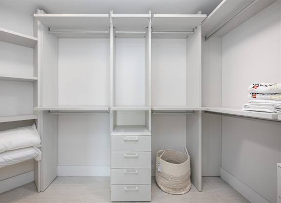 A white closet with drawers and shelves.