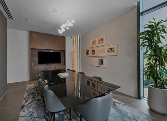 A modern dining room with a long table and chairs.