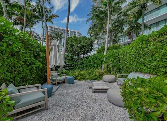 A garden with a gravel path and a white umbrella.