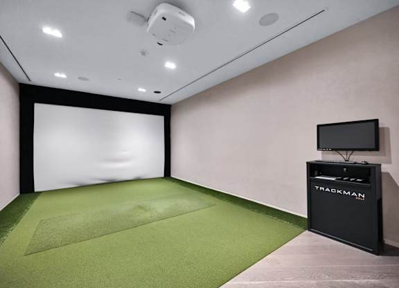 A room with a green carpet and a black box labeled