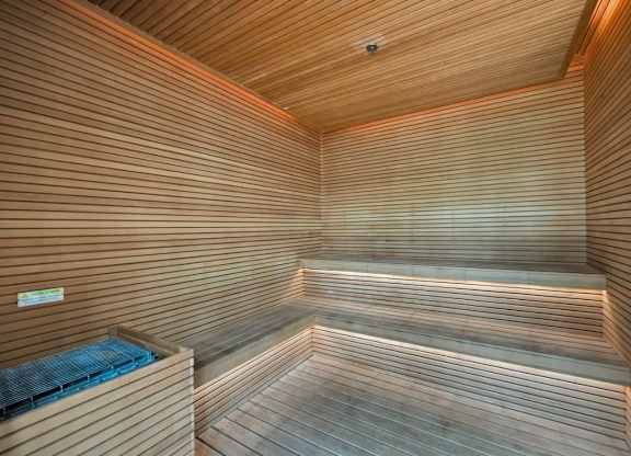 A wooden sauna with a bench and a heater.