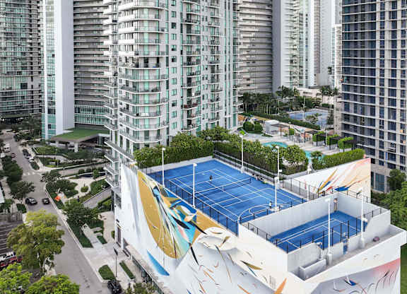 A tennis court is located on the roof of a building.