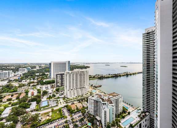 A cityscape with a large body of water in the background.
