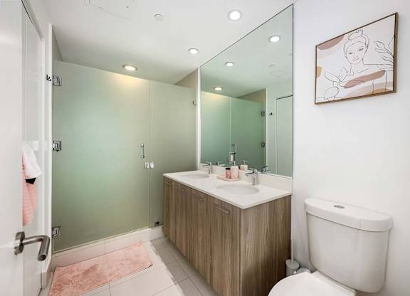 A bathroom with a white toilet, a sink, and a mirror.