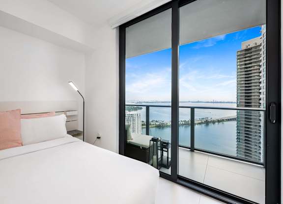 A bedroom with a large bed and a view of the city.