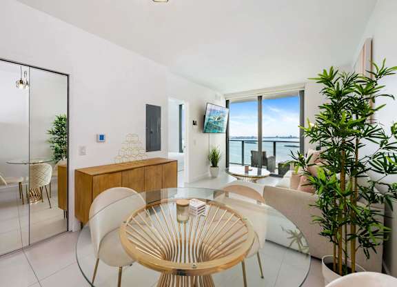 A modern dining room with a glass table and chairs.
