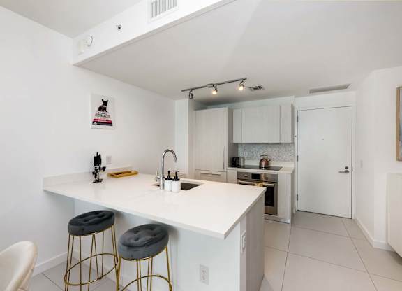 A kitchen with white cabinets and a white counter top.