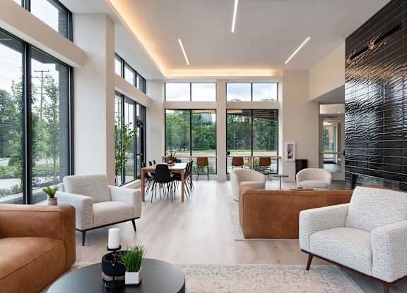 A modern living room with white furniture and a large window.