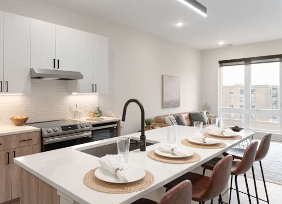A modern kitchen with a dining table set for two.