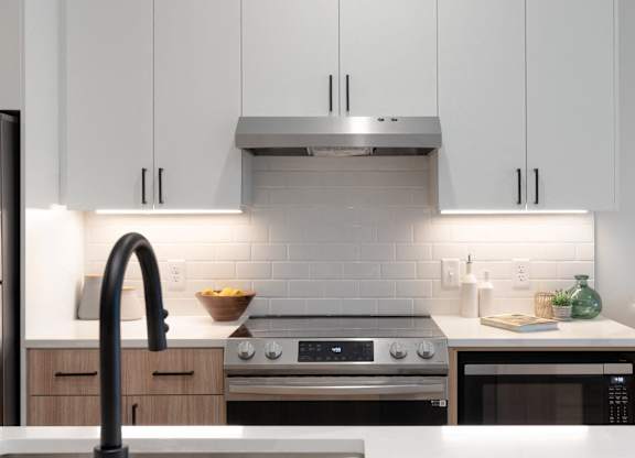 A modern kitchen with a stainless steel range hood above the stove.
