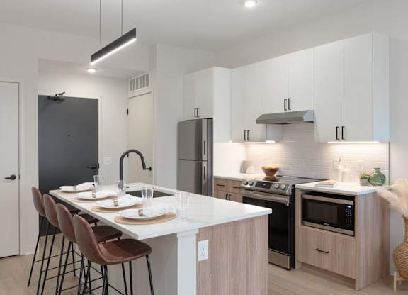 A modern kitchen with a white countertop and wooden cabinets.