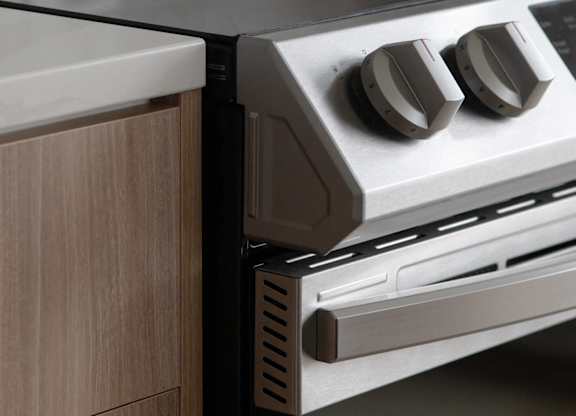 A modern oven with two knobs is installed in a kitchen.