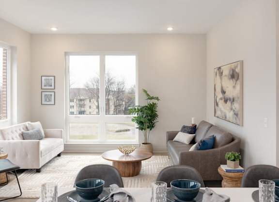 A living room with a couch, chairs, and a table with bowls on it.