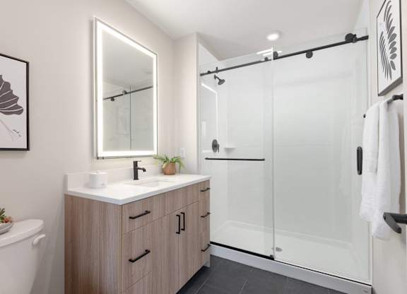 A modern bathroom with a white sink and a large mirror.