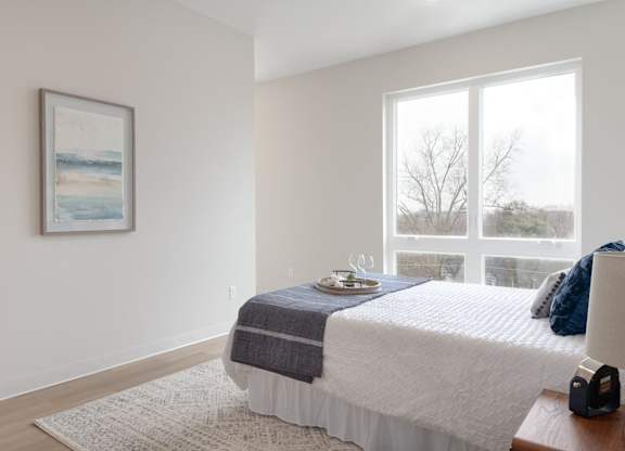 A bedroom with a large bed and a painting on the wall.
