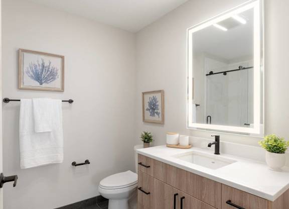 A white towel hangs on a towel rack in a bathroom.